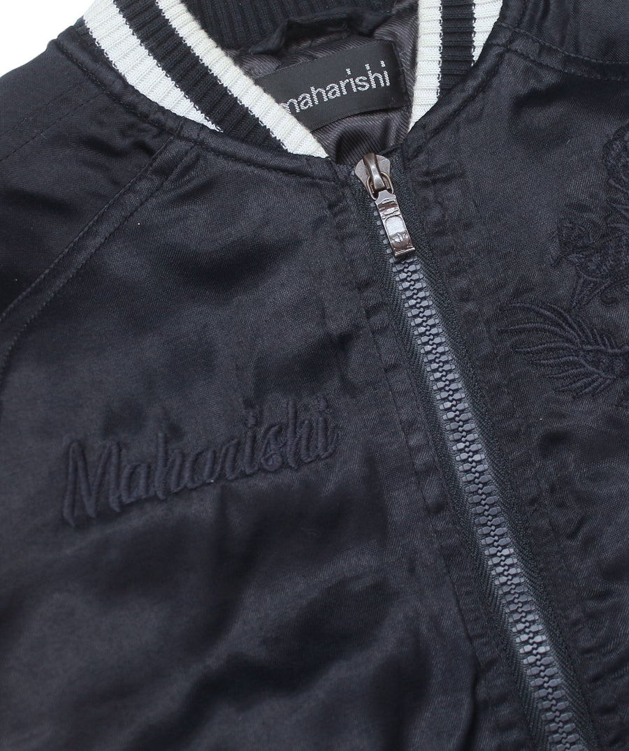 MAHARISHI Tour Jacket B22MH5220 features signature embroidery on a classic souvenir silhouette, blending military style with sustainable design.