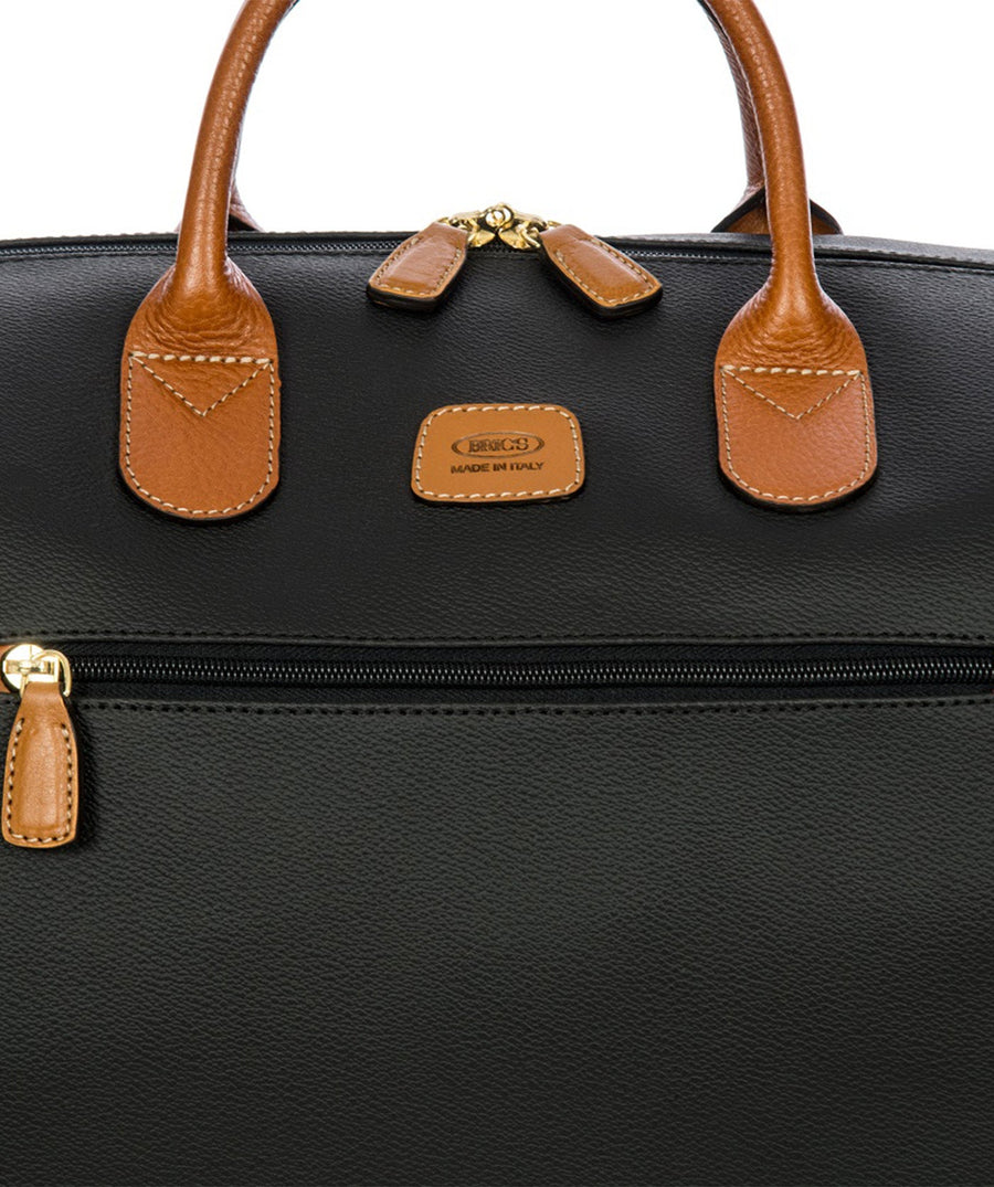 Bric's 22" Firenze Cargo Duffle Bag in black with brown leather accents, featuring double top handles, a front zip pocket, gold-tone zippers, and a spacious interior with logo-printed lining and an inner zip pocket. Style code BBJ20202.